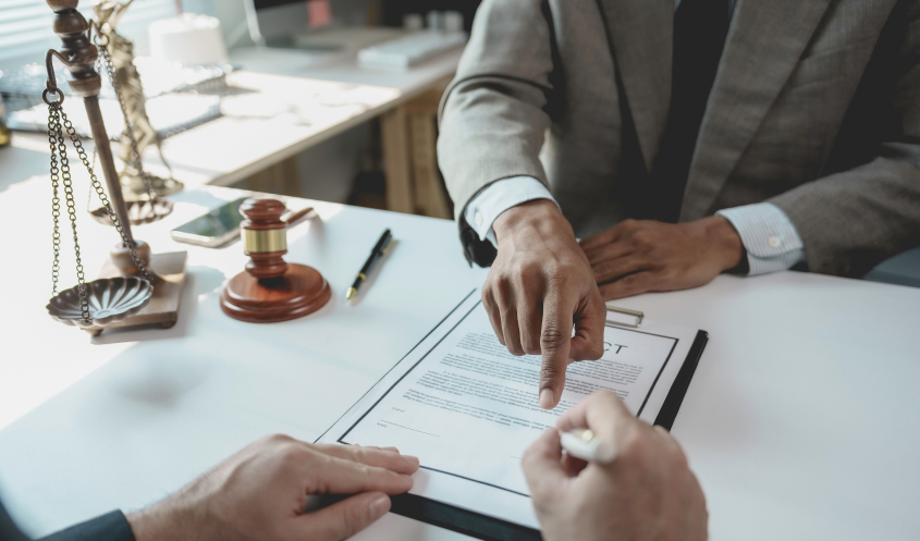 A corporate attorney points at a contract.