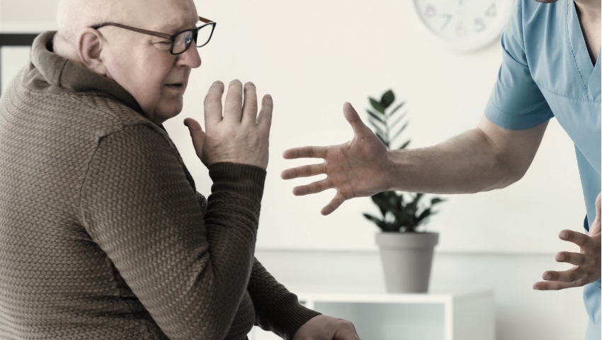 elderly man being verbally abused by nursing home employee