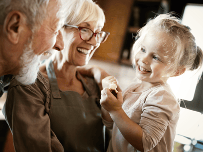 grandparents having fun in the kitchen with their young granddaughter