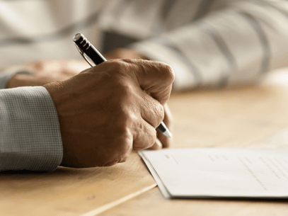 close-up of a grandfather's hand signing a form to gain grandparent's rights over their grandchild