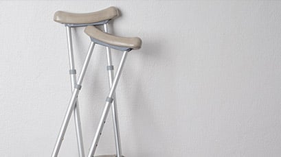 Crutches leaning up against a gray wall