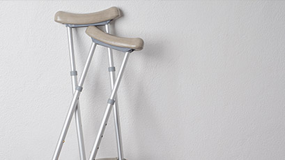 Crutches leaning up against a gray wall