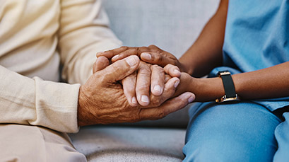 Daughter holding hands with her elderly mother